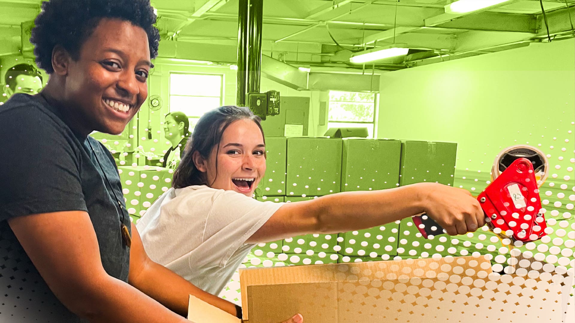 Two people from food bank posing as they tape up a box