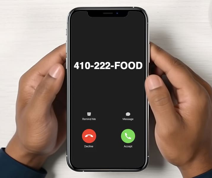 Person holding a phone that say 410-222-FOOD is calling