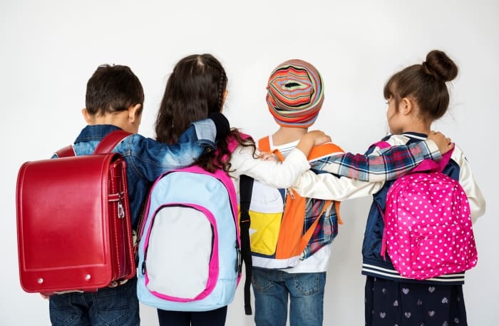 Children in backpacks standing side by side