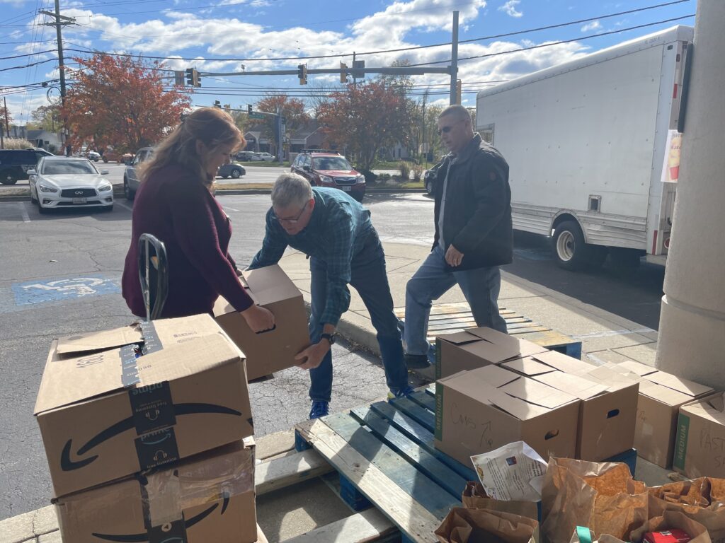 Remax Experience Realtors loading their food donation into the Anne Arundel County Food Bank truck.